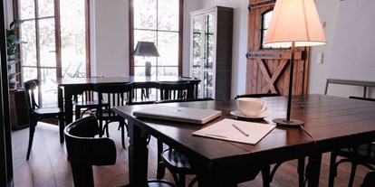 Coworking Spaces - Der Co Working Raum hat 2 Tische an denen bis zu max. 6 Personen sitzen können. Der Blick aus den Fenstern geht über die Terrasse zum See und zum alten Verwaltergebäude der Gutsanlage. - Co Working & Vacation// Rittergut Damerow