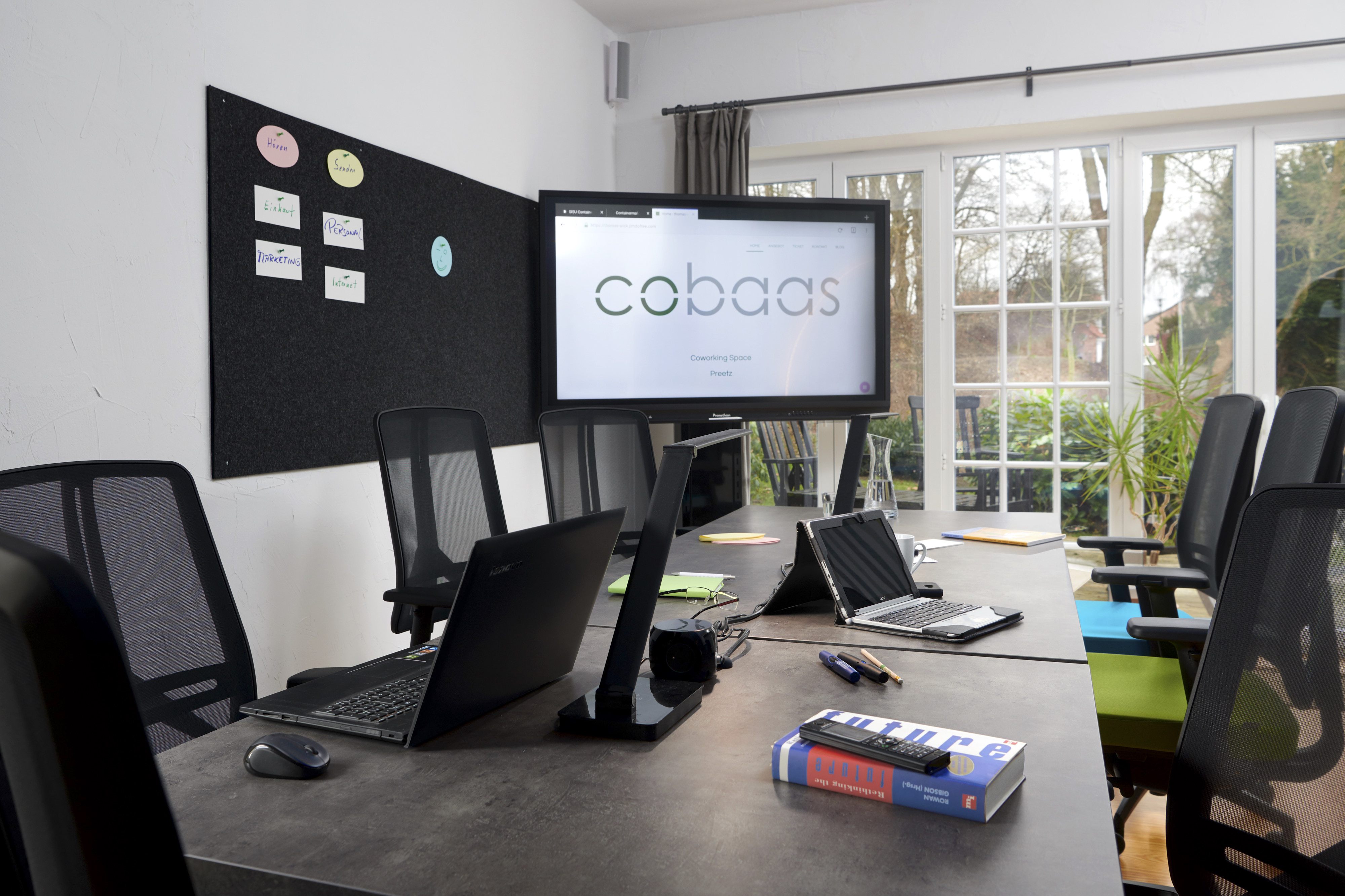 Coworking Space - cobaas - SeminarLounge, langer Tisch mit mehreren Flex-Desk-Plätzen, ergonomischen Drehstühlen, Aktiv-Panel, Sessel, Kaminofen, Küchenzeile, Bad mit Dusche - cobaas