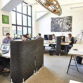 Coworking Space: Coworking Space mit höhenverstellbaren Tischen und Monitoren und viel Tageslicht lädt zum produktiven Arbeiten ein - b+office