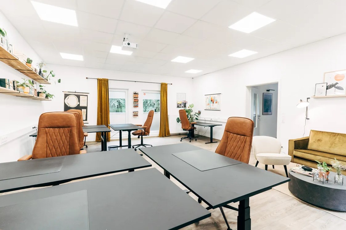Coworking Space: Büroraum mit höhenverstellbaren Schreibtischen und Sitzecke - herrliches coworking