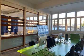 Coworking Space: Bürolandschaft mit grünen Tischen von der Uni Zürich - Gloria Coworking Lenzburg