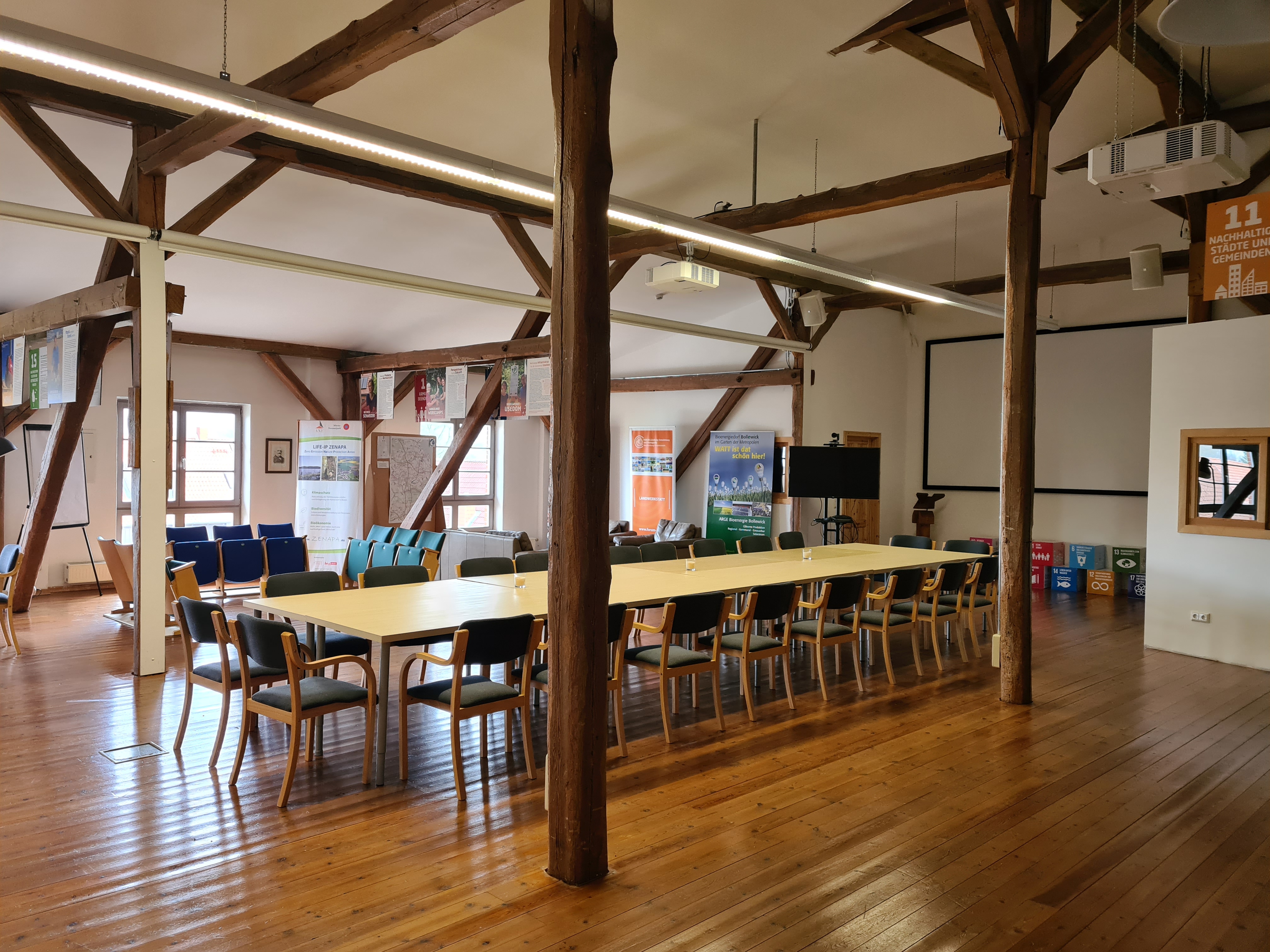 Coworking Spaces - Mecklenburg-Vorpommern - Unser Raum "Dorfkern" kann für Tagungen bequem bis 35 Personen und für Vorträge bis max. 50 Personen genutzt werden. 
Der Raum verfügt über 4 Leinwände, Beamern, HDMI Kabel, Präsentationsmonitor und optional stellen wir analoge Präsentationelemente, wie eine traditionelle Schultafel, 2 neue Metaplanwände, Flipcharts, etc. auf.. Tische und Stühle sind enthalten. Der Raum bietet ebenfalls 2 gemütliche Sitzecken mit Ledercouch und Kinobestuhlung. 
Auf Anfrage kann die angrenzende Küche genutzt werden.  - Die Scheune Bollewick