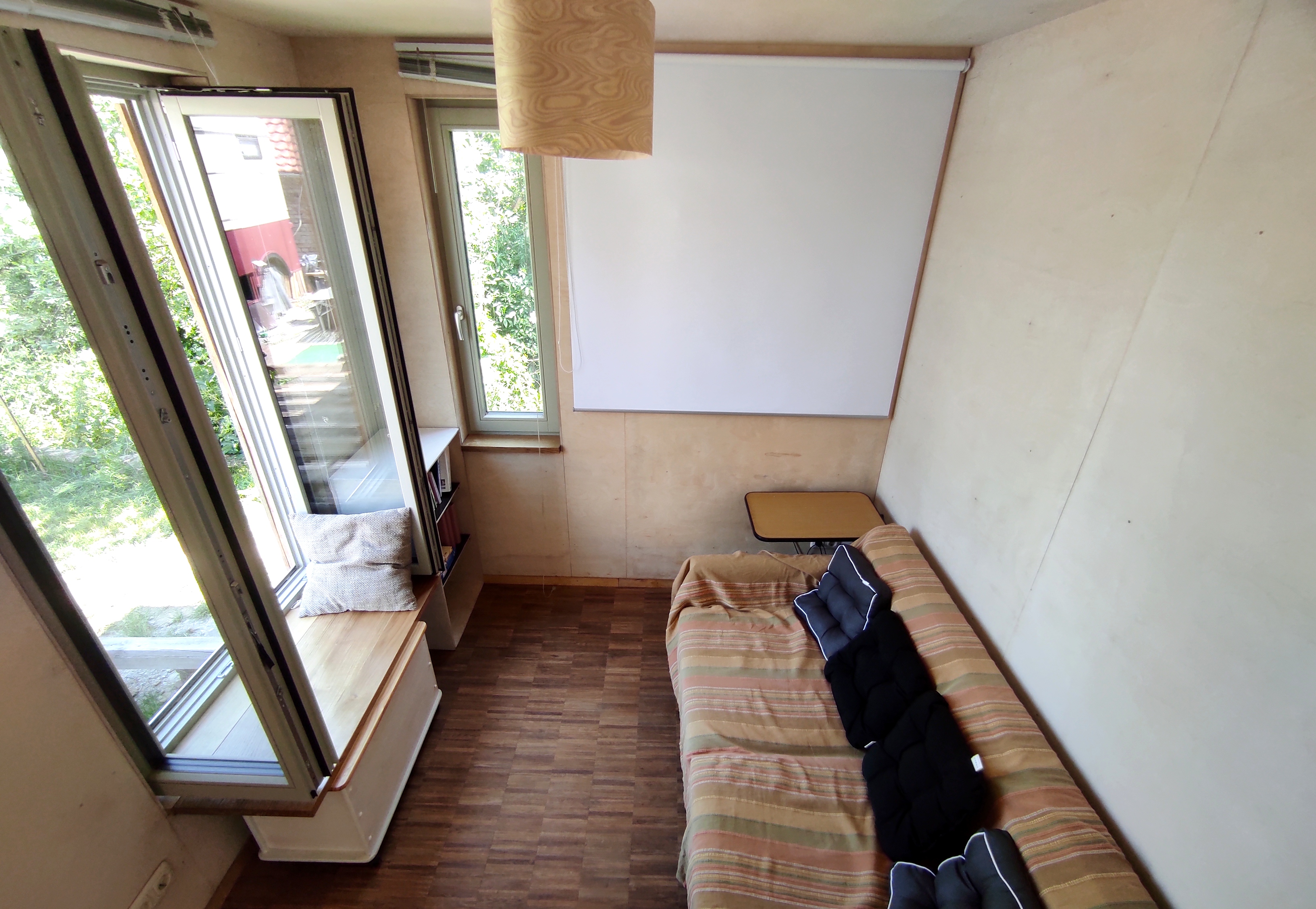 Coworking spaces - Thüringen Nord - Wohnbereich mit Beamerleinwand, Fensterbank, Couch - Winterspace cosyTinyhouse Großburschla