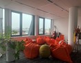 Coworking Space: Abseits der klassischen Meetingräume kann auch unsere Freifläche zum Arbeiten und zum Austausch genutzt werden. Egal ob Sessel-Ecke, Sitzsäcke oder Stehtische - Für jeden ist etwas dabei. - kuehlhaus AG Experience Space