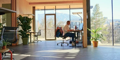 Coworking Spaces - Zugang 24/7 - Österreich - Coworking Space mit höhenverstellbaren Tischen und Blick auf die Alpen - Impact Hub Tirol