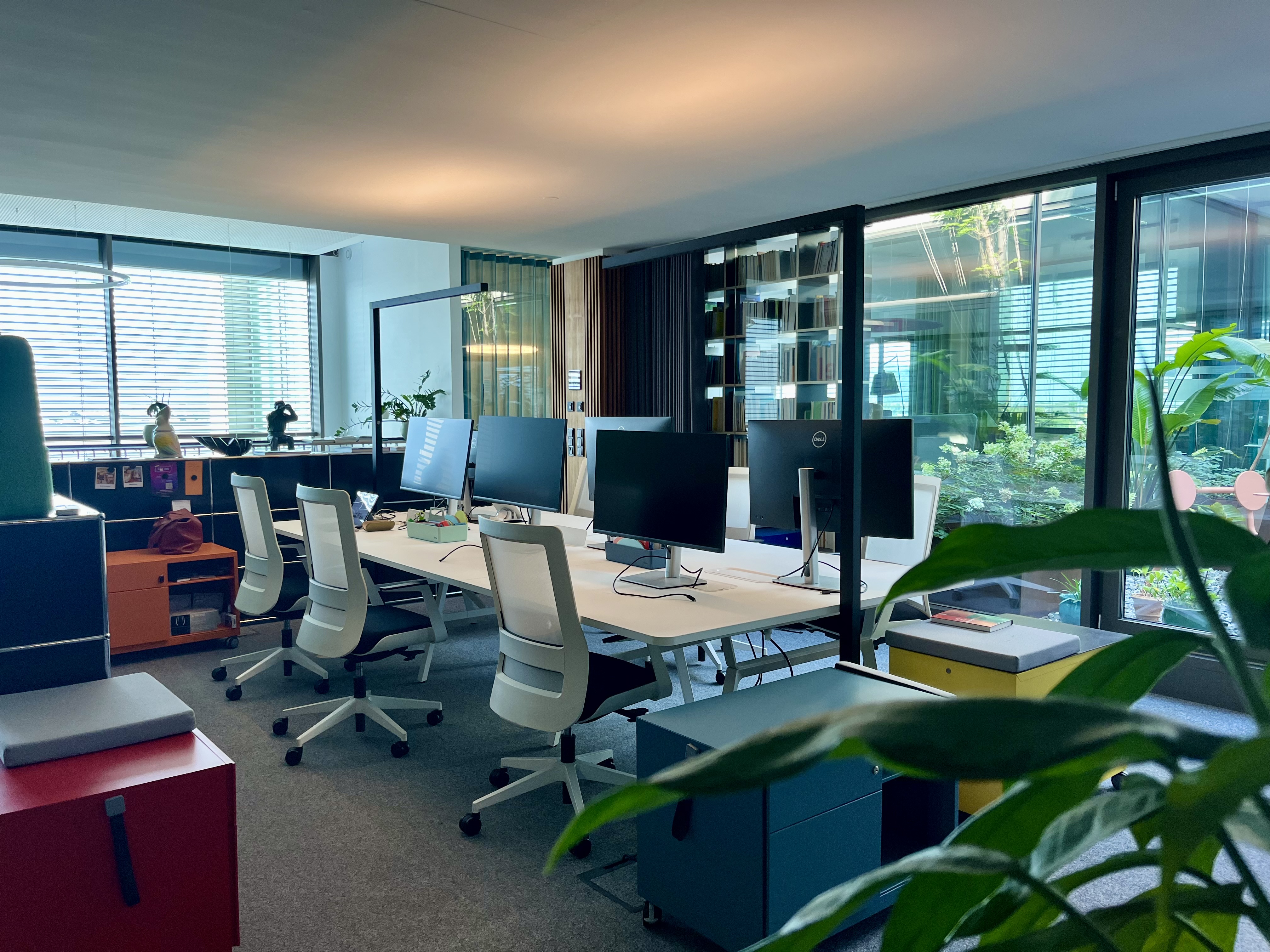 Coworking Spaces - Flex Desk mit Bildschirm & buntem Trolley und Blick ins Grüne - bluebird.space