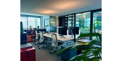 Coworking Spaces - Zugang 24/7 - Salzburg-Stadt (Salzburg) - Flex Desk mit Bildschirm & buntem Trolley und Blick ins Grüne - bluebird.space